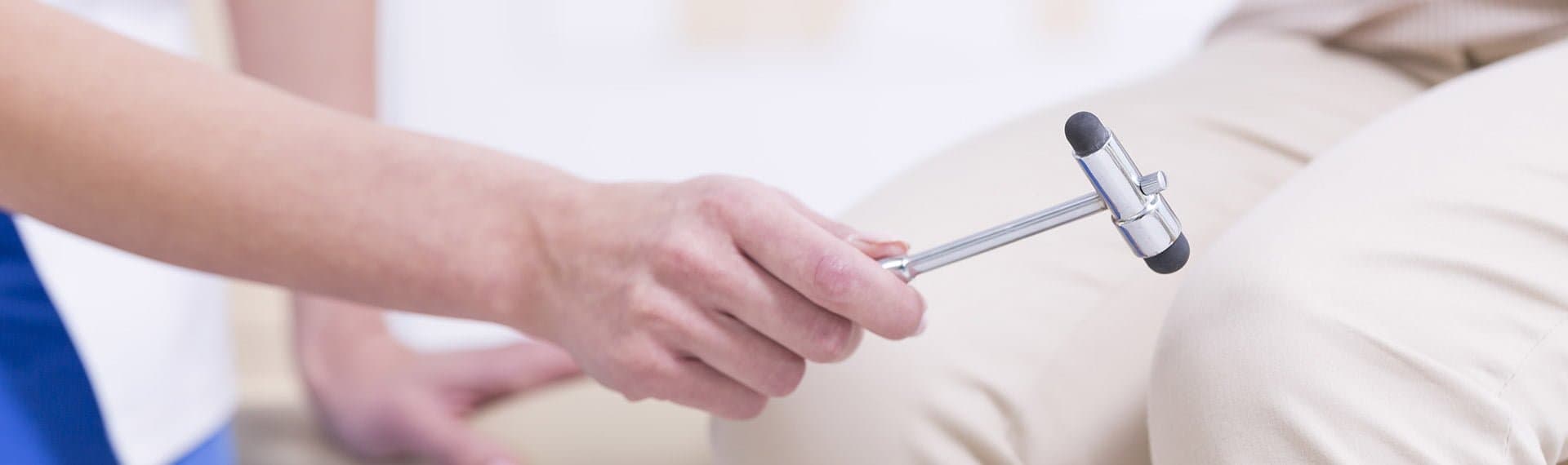 doctor testing patients knee reflexes