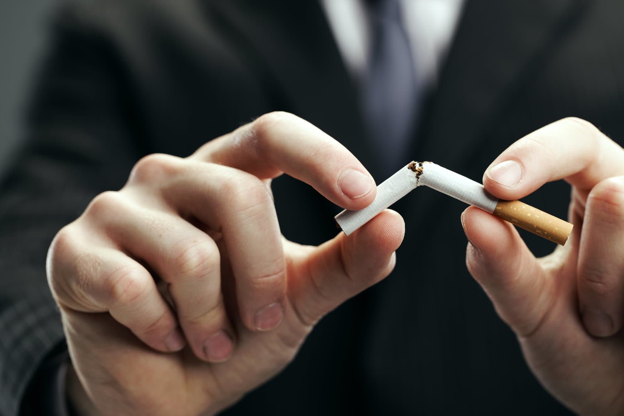 Human hands breaking cigarette