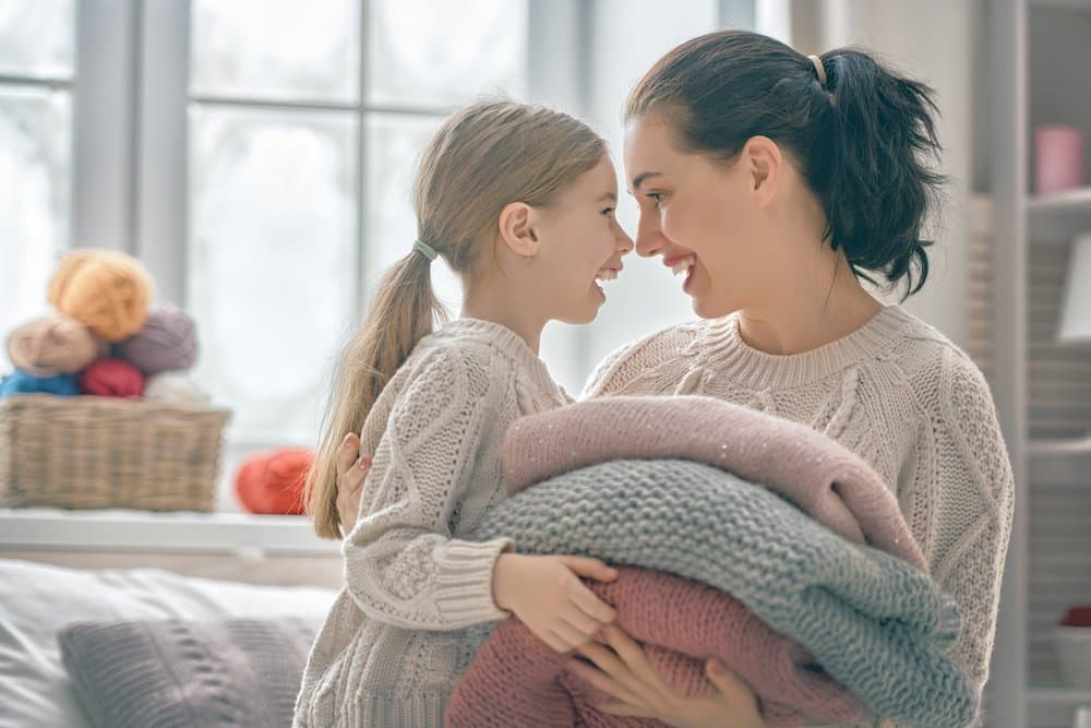 Mom and child in sweaters smiling