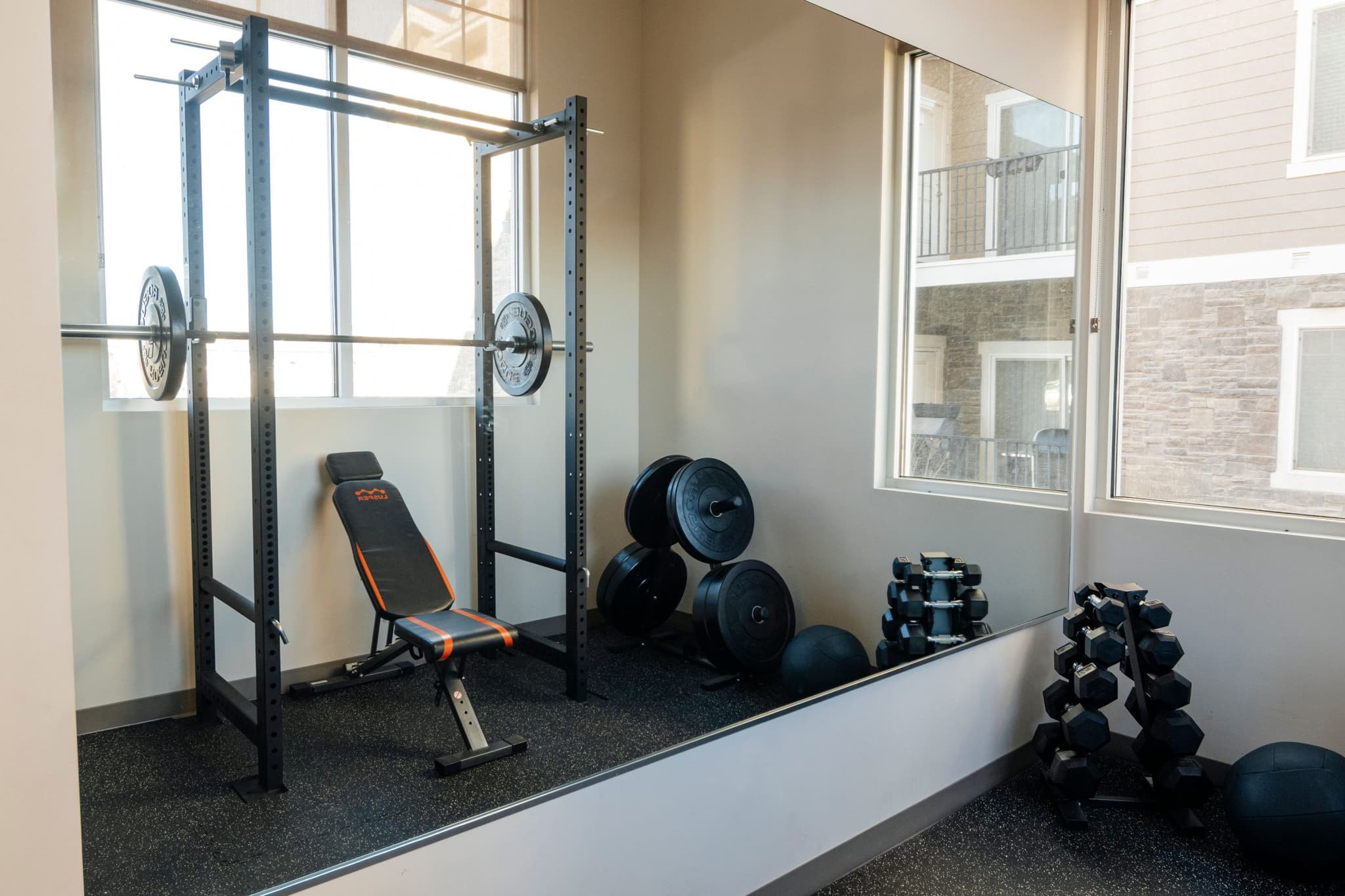 Image of Fitness room with dumbbells and mirrors to support strength training as part of the center’s holistic approach.
