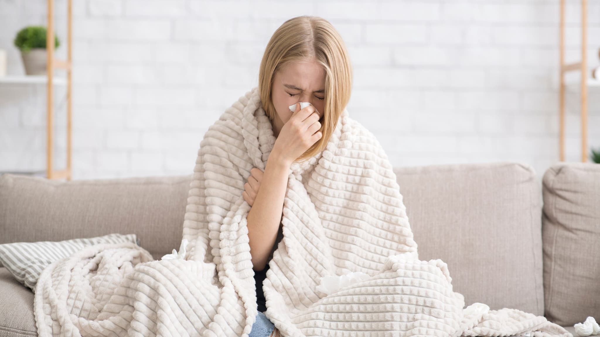 Picture of Young girl got sick, wrapped in blanket blowing nose