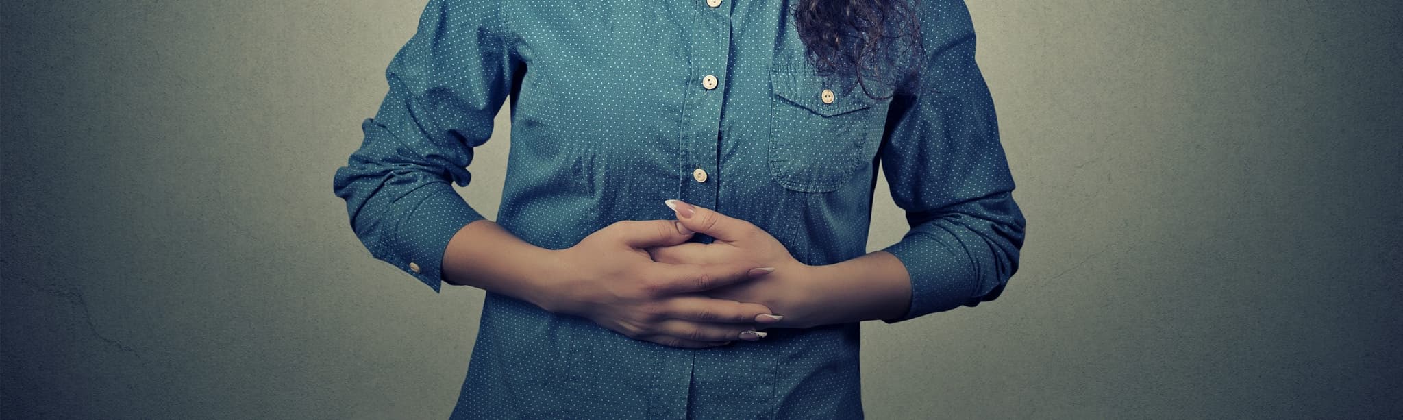 Picture of woman holding stomach in pain - UTI