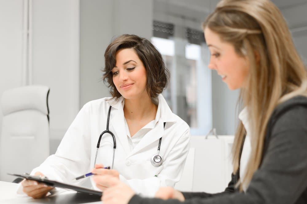Picture of doctor with clipboard explaining things to patient
