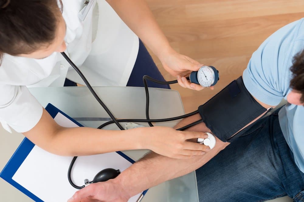 Picture of Doctor Measuring Blood Pressure Of Male Patient