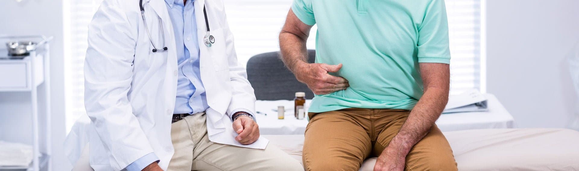 man with stomach pain showing doctor