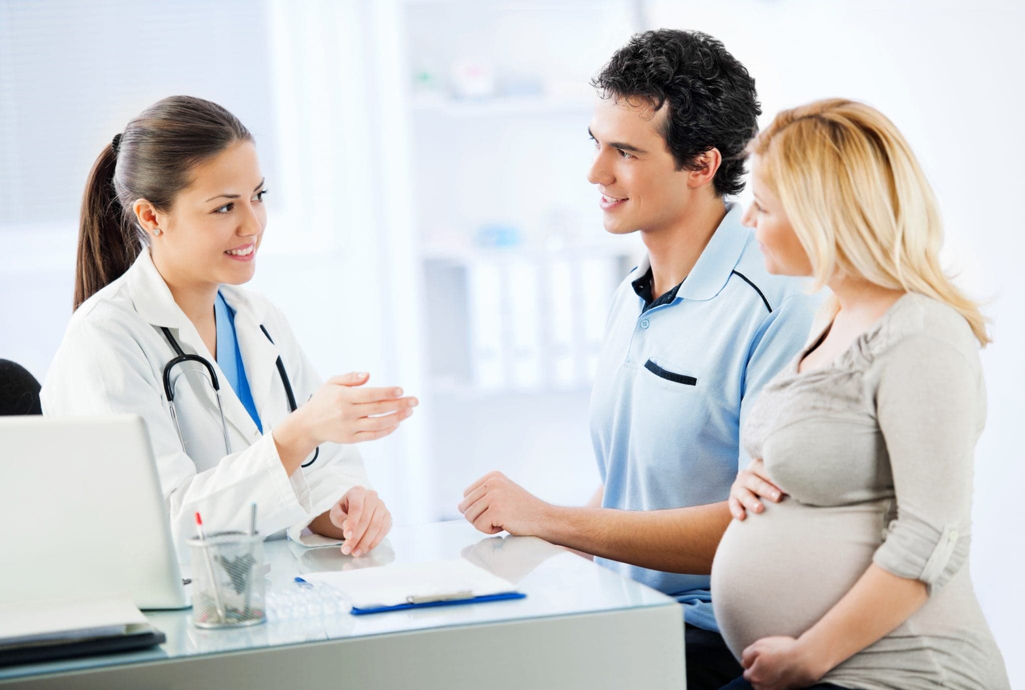 Image of Young cheerful couple visiting a doctor