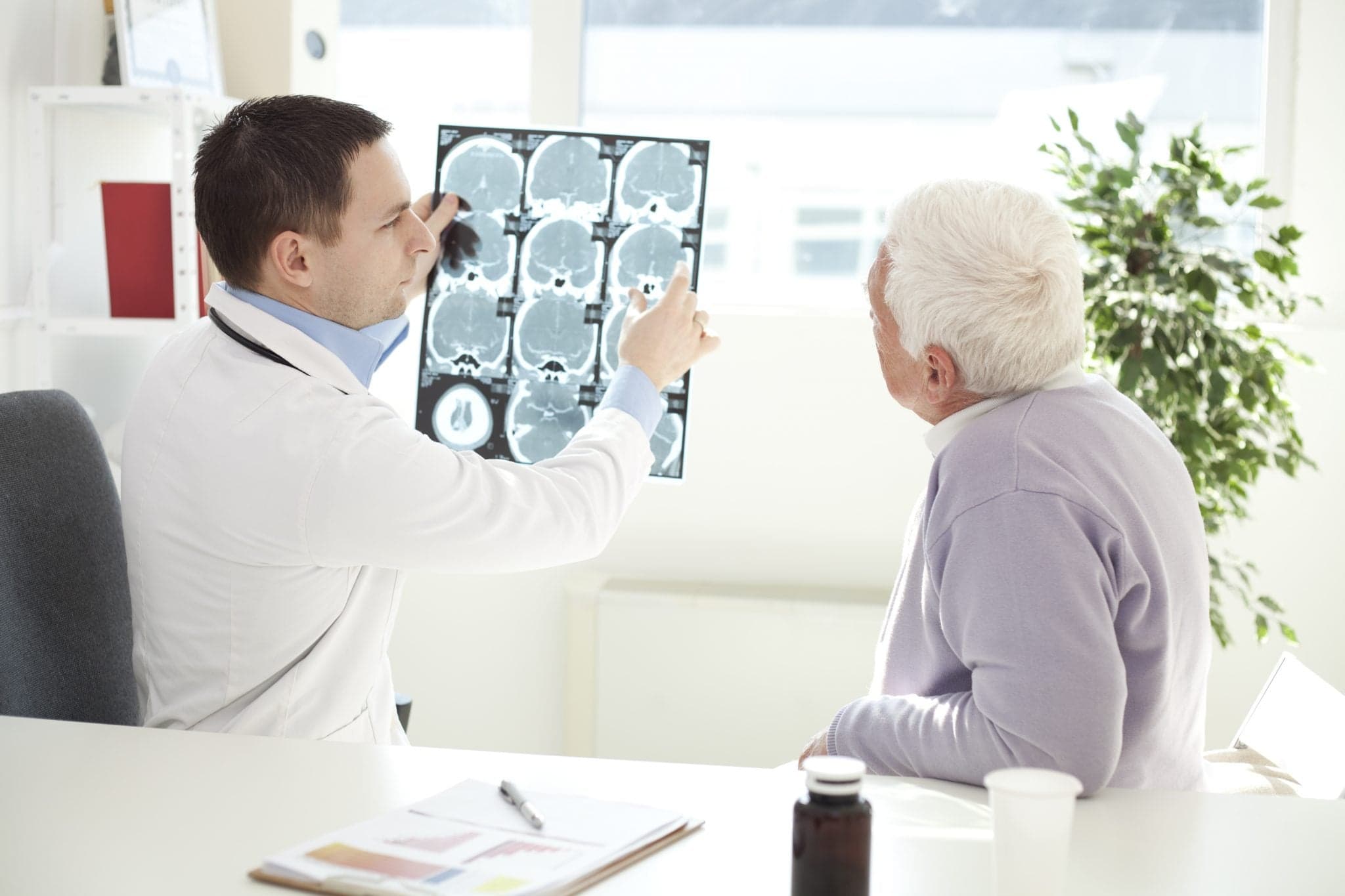 Senior man visiting doctor - looking at brain scan
