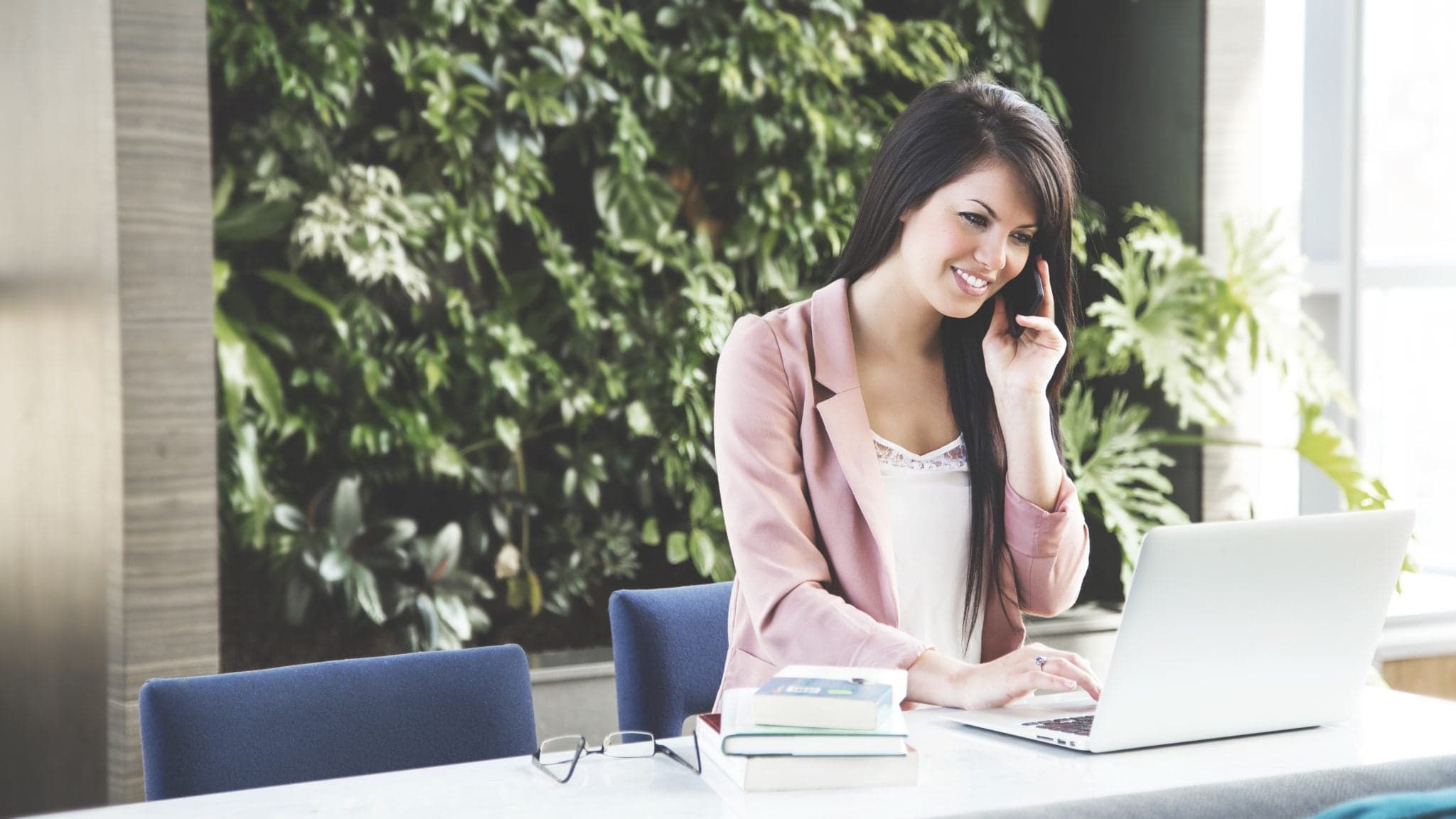 Picture of woman talking on phone while working on her laptop