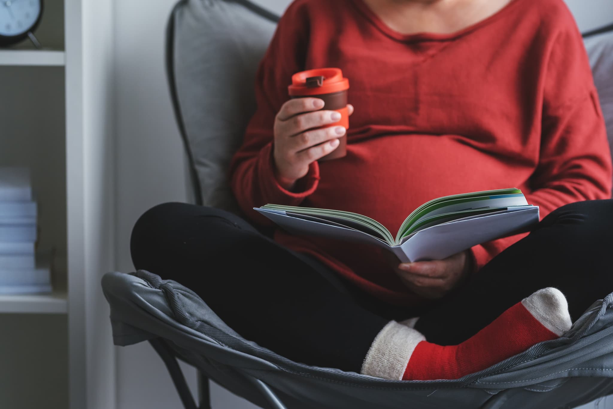 Picture of Pregnant woman reading book in living room