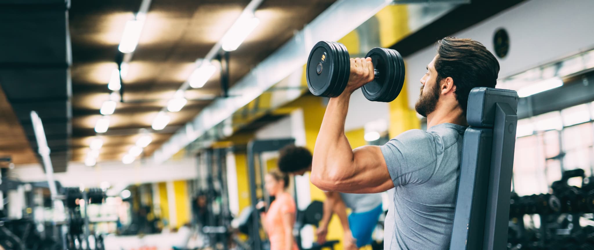 Young handsome strong man doing exercises in gym