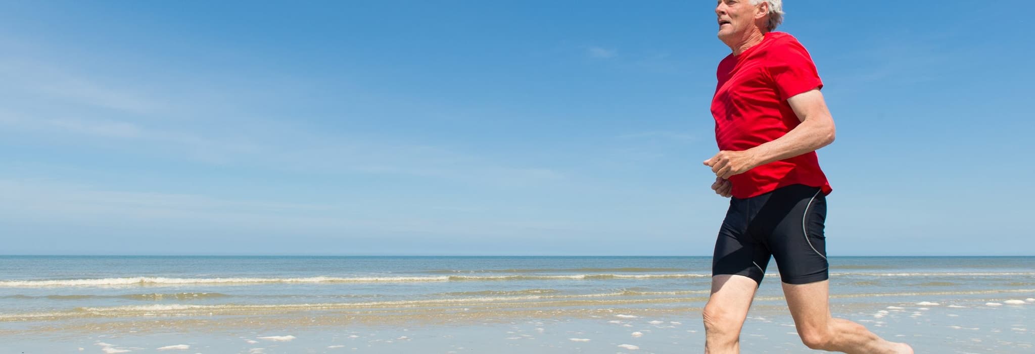 elderly person running by ocean